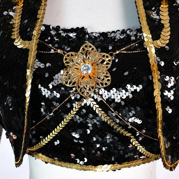 Close-up of the gold filigree brooch, crystal centre and draped chains on the Mira kids costume crop top