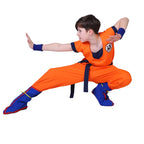 Boy in a fighting stance wearing the Goku kids costume, showing the sash tails and boot covers