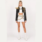 Adult model wearing the Rumi costume: black sequin jacket, gold shoulder armour, white crop top and shorts with belt and waist chains